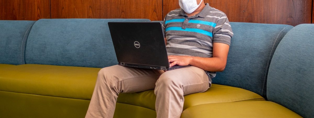 Student using a laptop wearing a mask